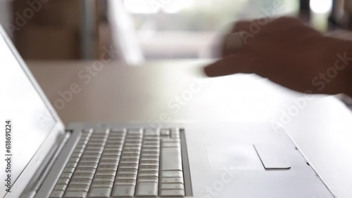 Businessman's hand with financial charts and mobile phone over a laptop on the table