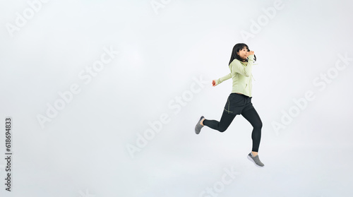 ジャンプするスポーツウェアを着た女性 © metamorworks