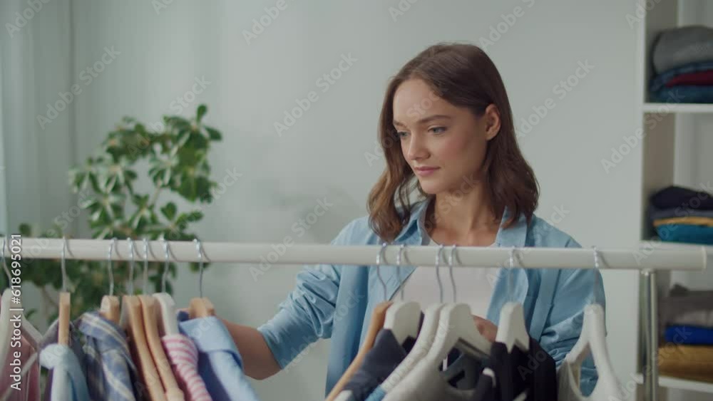 Smiling Young Woman Sorts Through Her Wardrobe to Find the Right Clothes for the Season, Concentrated Woman Reviews her Wardrobe, Selects and Discards Old Clothes, Seasonal Fashion, Wardrobe Makeover Smiling Young Woman Sorts Through Her Wardrobe to Find the Right Clothes for the Season, Concentrated Woman Reviews her Wardrobe, Selects and Discards Old Clothes, Seasonal Fashion, Wardrobe Makeover