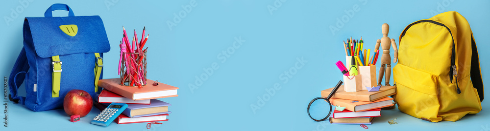 Cups with school stationery, wooden mannequin and backpack on blue background Cups with school stationery, wooden mannequin and backpack on blue background