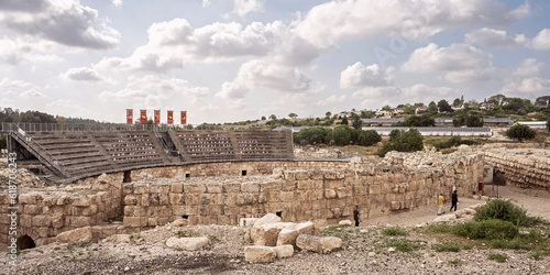 reconstructed ancient roman amphitheater at beit guvrin park in israel with a modern settlement and partly cloudy sky in the background photo