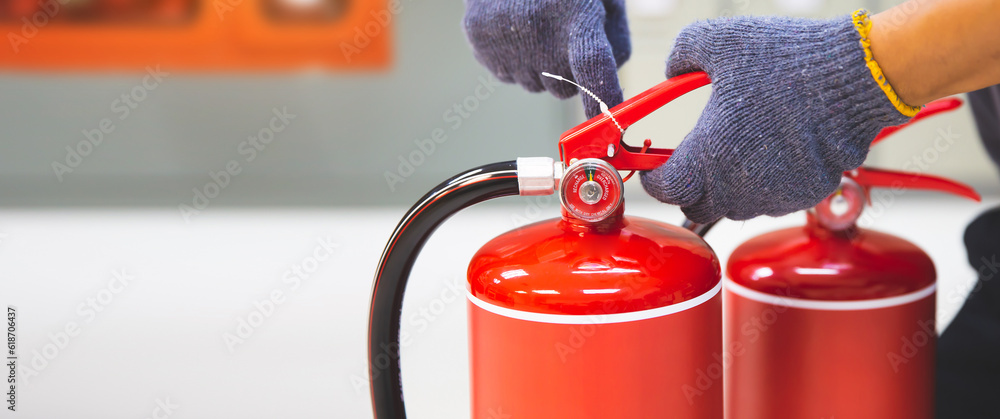 Fire extinguisher has hand engineer checking safety pin and pressure gauges fire extinguishers equipment for protection and prevent emergency case and or rescue and alarm system training concept.