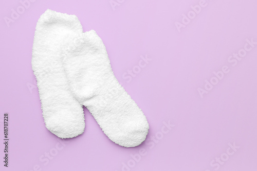 Pair of warm white socks on lilac background