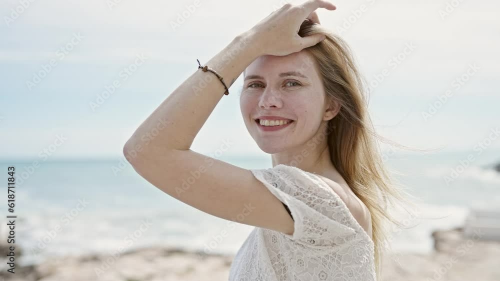 Young blonde woman tourist smiling confident touching hair at beach Young blonde woman tourist smiling confident touching hair at beach
