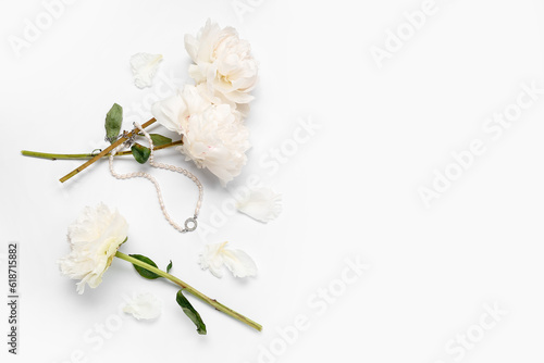 Composition with stylish female necklace and beautiful peony flowers on white background