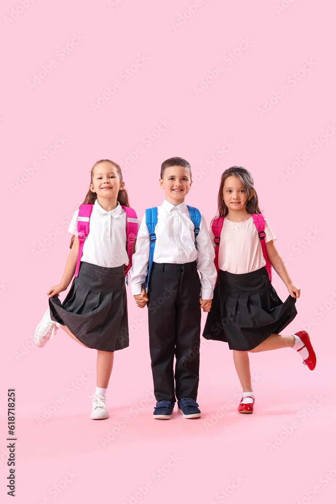 Fototapeta premium Little schoolchildren on pink background