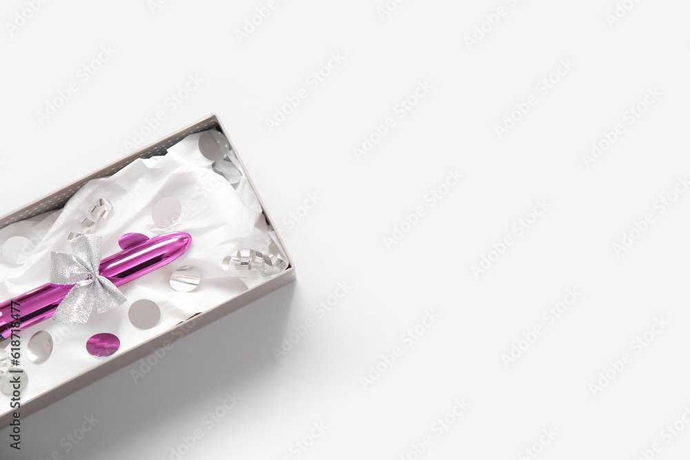 Gift box with vibrator and confetti on white background Gift box with vibrator and confetti on white background