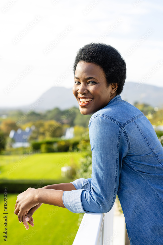 Portrait of happy african american woman staying on sunny terrace Portrait of happy african american woman staying on sunny terrace
