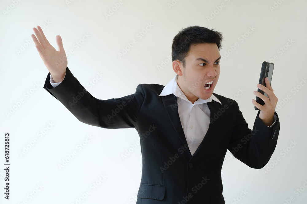 A young Asian boss is angry on the phone. Isolated white background.