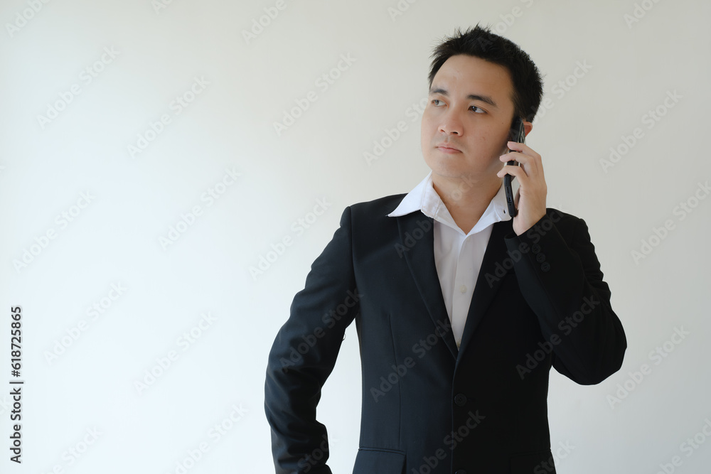 Young Asian businessman calling someone on the smartphone. Isolated white background. Young Asian businessman calling someone on the smartphone. Isolated white background.