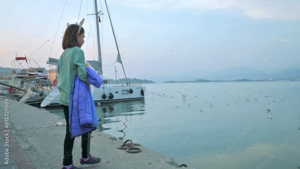 The girl feeding seagulls near the sea. 4k footage UHD 3840x2160 The girl feeding seagulls near the sea. 4k footage UHD 3840x2160