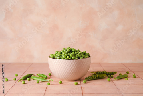 Bowl with fresh green peas on pink tile table