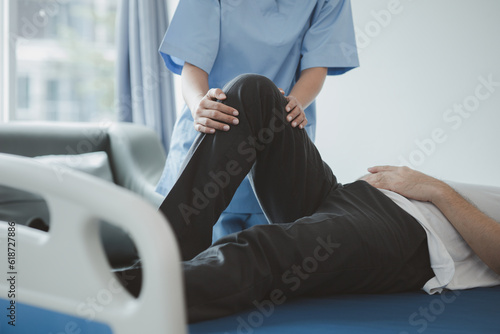 A professional physiotherapist is stretching the patient's legs, the patient has muscle dysfunction due to hard work, most often an office worker who has problems sitting for long periods of time.