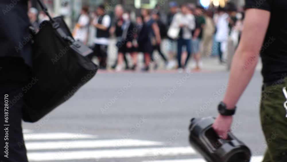 SHIBUYA, TOKYO, JAPAN - MAY 2023 : Crowd of people walking at Shibuya crossing in daytime. Busy downtown area in Tokyo. Japanese people, urban city life and metropolis concept video. Slow motion shot. SHIBUYA, TOKYO, JAPAN - MAY 2023 : Crowd of people walking at Shibuya crossing in daytime. Busy downtown area in Tokyo. Japanese people, urban city life and metropolis concept video. Slow motion shot.