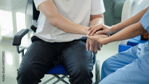 Male patient sitting in wheelchair undergoing a medical examination with specialist physician, treating injuries Getting medical treatment from specialist doctor can get the right and proper treatment
