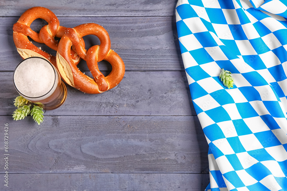 Flag of Bavaria, mug with beer and pretzels on blue wooden background Flag of Bavaria, mug with beer and pretzels on blue wooden background
