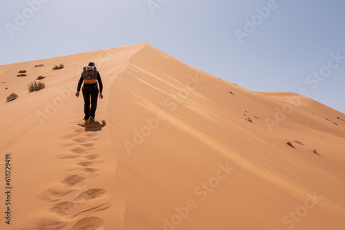 Hiking up the Great Dune of Merzouga in the Erg Chebbi desert photo