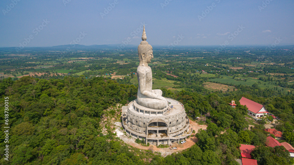 .aerial view Big white buddha statue on mountain for thai people travel visit and respect .praying at Wat Roi Phra Phutthabat Phu Manorom on May 15, 2017 in Mukdahan, Thailand. Kong river background..