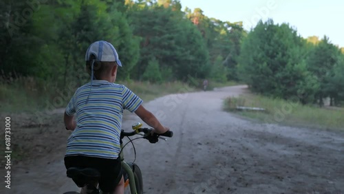 The boy riding his bike in the forest. 4k video footage  photo