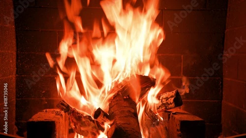 Home fireplace with red flame and firewood. 4K video relaxing endless footage