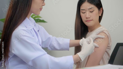 Fotografie Beautiful asian woman doctor injecting in arm of asian girl.