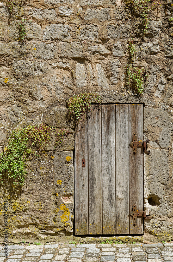 weathered wooden door in an old historic wall, Rothenburg ob der Tauber, Bavaria, Germany