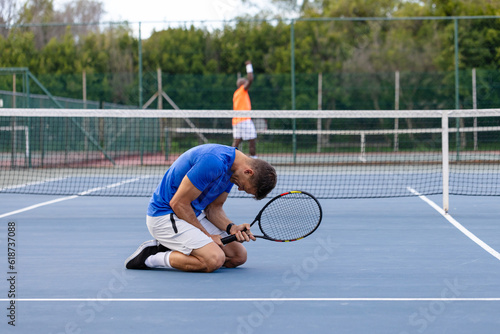 Diverse male tennis players playing tennis and losing game on outdoor court