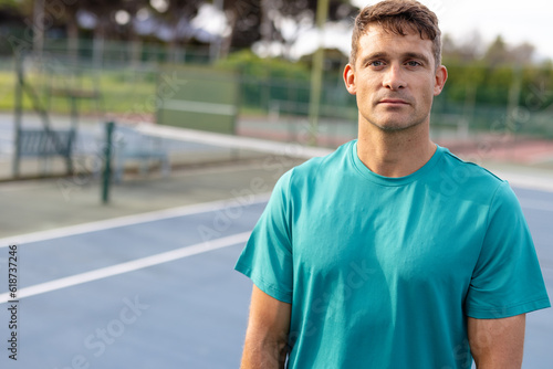 Portrait of caucasian male tennis player wearing green t shirt on outdoor court, copy space