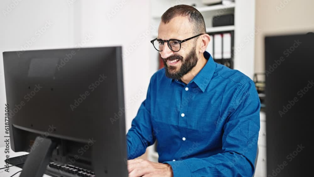 Young hispanic man business worker using computer with winner gesture at office Young hispanic man business worker using computer with winner gesture at office