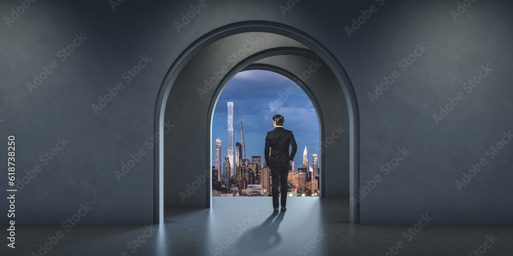 Businessman in modern office loft with mockup wall, New York city at night
