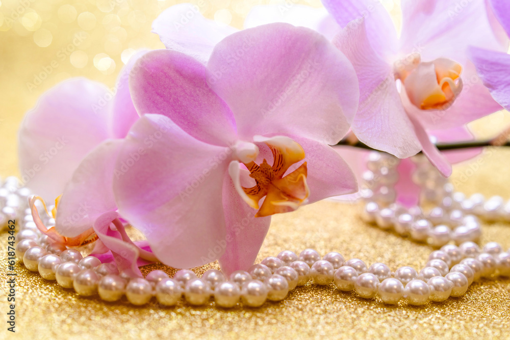 Fototapeta premium purple Orchid and pearl necklace on a shiny gold background 