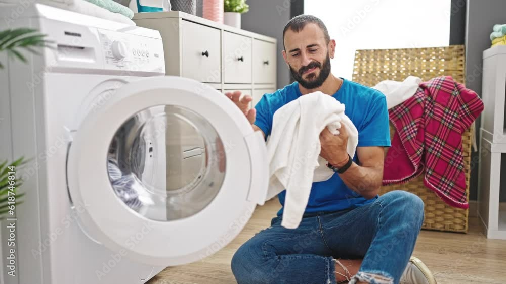 Young hispanic man smiling confident washing clothes at laundry room Young hispanic man smiling confident washing clothes at laundry room