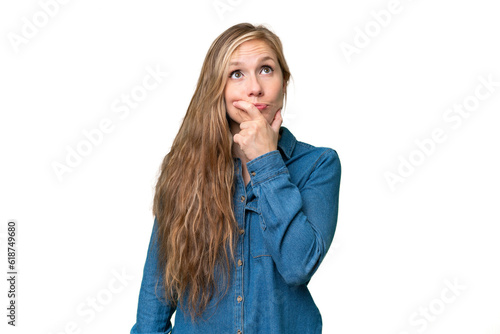 Young blonde woman over isolated background having doubts and with confuse face expression