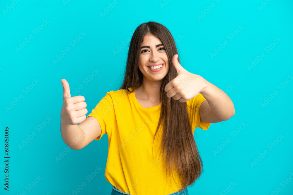 Young caucasian woman isolated on blue background giving a thumbs up gesture Young caucasian woman isolated on blue background giving a thumbs up gesture