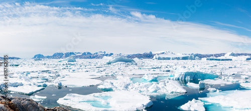 Melting icebergs by the coast of Greenland, on a beautiful summer day - Melting of a iceberg and pouring water into the sea - Greenland - Tiniteqilaaq, Sermilik Fjord, East Greenland