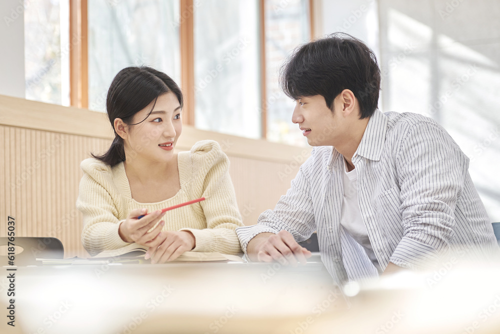 Colleague, friend, motivator, young male model comforting a distressed young female college student model sitting at a desk in a university classroom in Asia Korea. Colleague, friend, motivator, young male model comforting a distressed young female college student model sitting at a desk in a university classroom in Asia Korea.