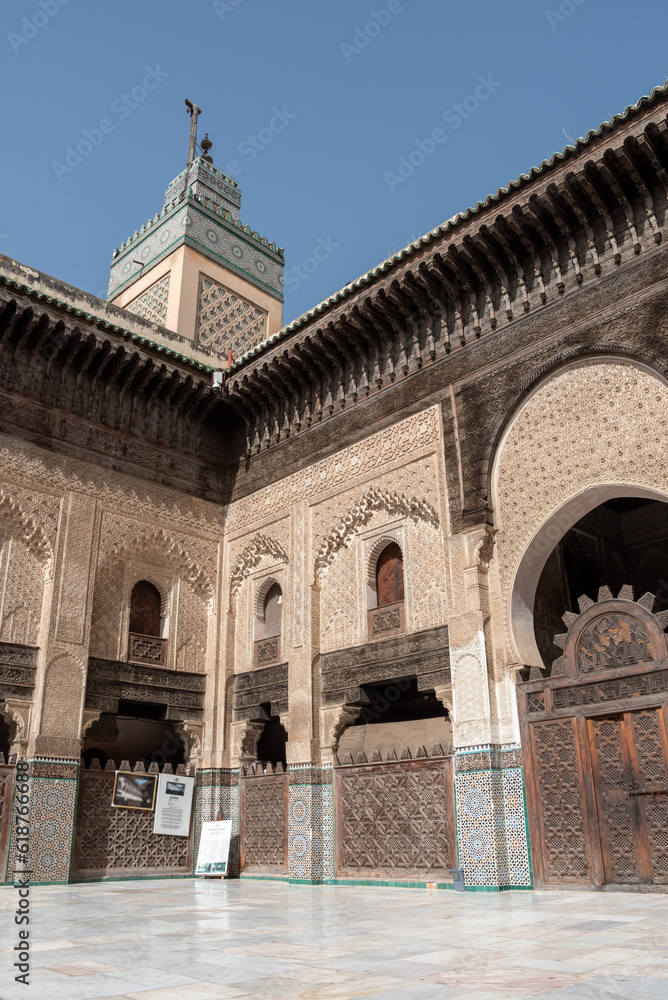 FES, MOROCCO - APRIL 01, 2023 - Traditional oriental facade at the courtyard of madrasa Bou Inaniya in the medina of Fes FES, MOROCCO - APRIL 01, 2023 - Traditional oriental facade at the courtyard of madrasa Bou Inaniya in the medina of Fes