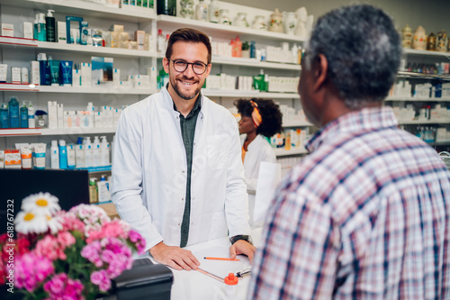 Portrait of a male pharmacist working in pharmacy and smiling while looking into the camera
