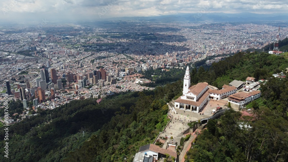Aerial view of a church on top of a green hill against the cityscape of Bogota, Venezuela