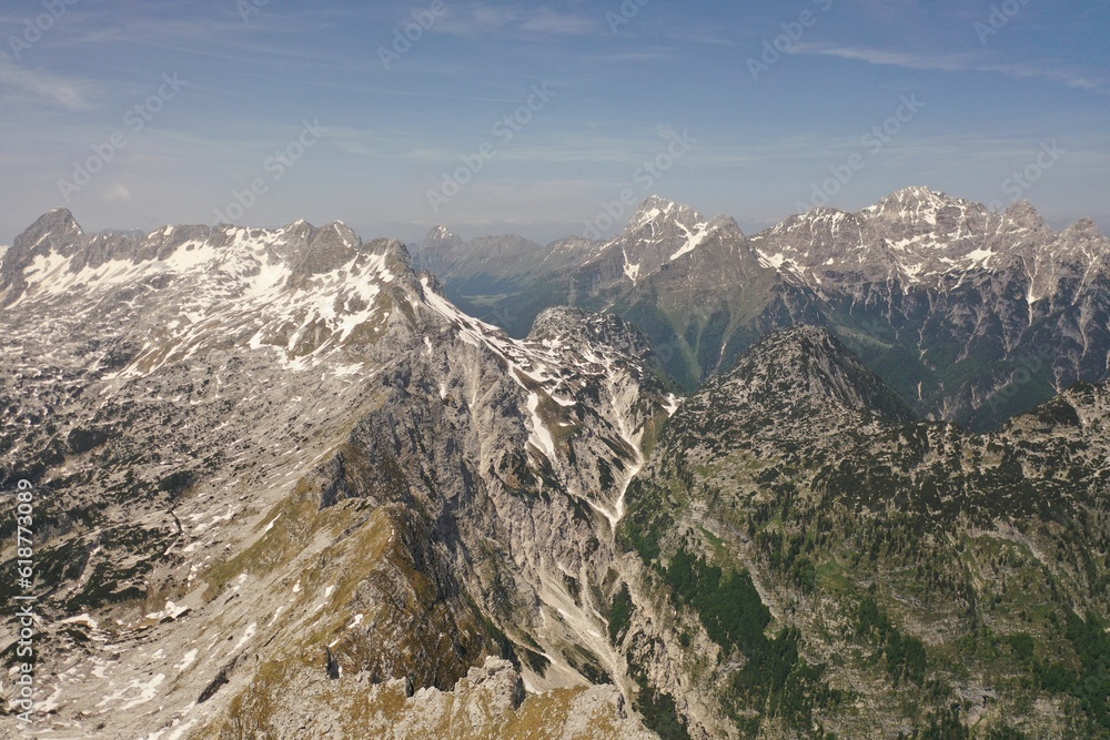 a snow - covered mountain ridge with trees and sky in the background a snow - covered mountain ridge with trees and sky in the background