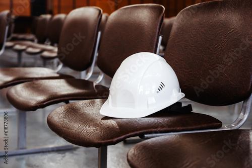 Fotografie Construction helmet on an empty seat in a conference room