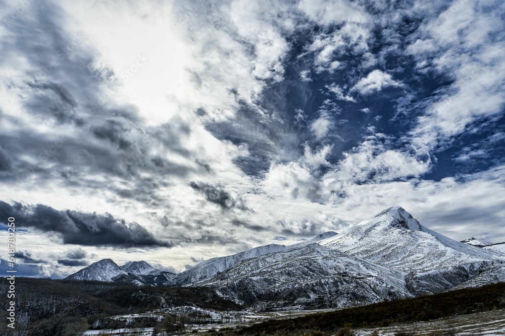 Scenic view of Palentina Mountain covered with snow under a cloudy blue sky in Spain