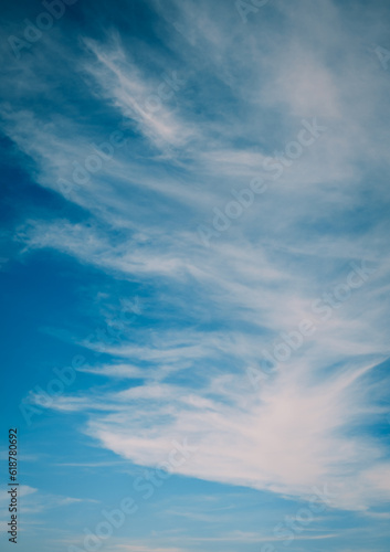 Vertical photo of white clouds on blue sky.