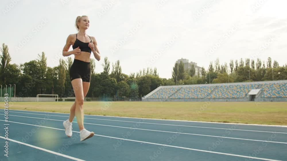 Pretty sporty blonde in skintight shorts and top running in the stadium on a sunny day. Stadium is equipped with football field and tribune seats. High quality 4k footage Pretty sporty blonde in skintight shorts and top running in the stadium on a sunny day. Stadium is equipped with football field and tribune seats. High quality 4k footage