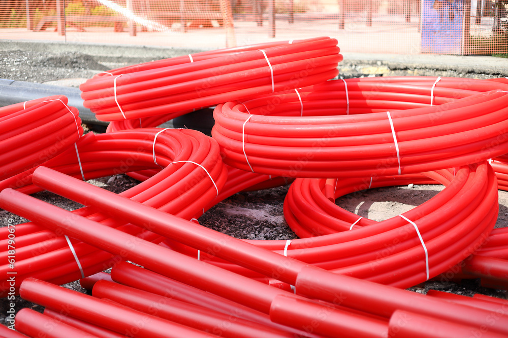 Red corrugated pipe for wire at construction site. Cable conduit for trenchless installations
