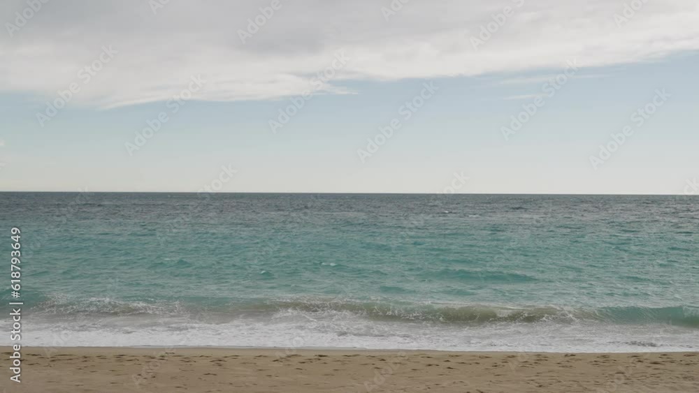 Clear blue waves with strong wind on a sandy empty beach in Cannes in spring Clear blue waves with strong wind on a sandy empty beach in Cannes in spring