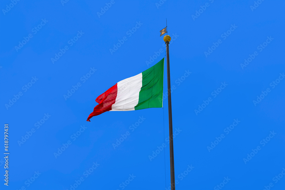 Italian flag blowing in the wind on blue sky