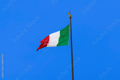 Italian flag blowing in the wind on blue sky