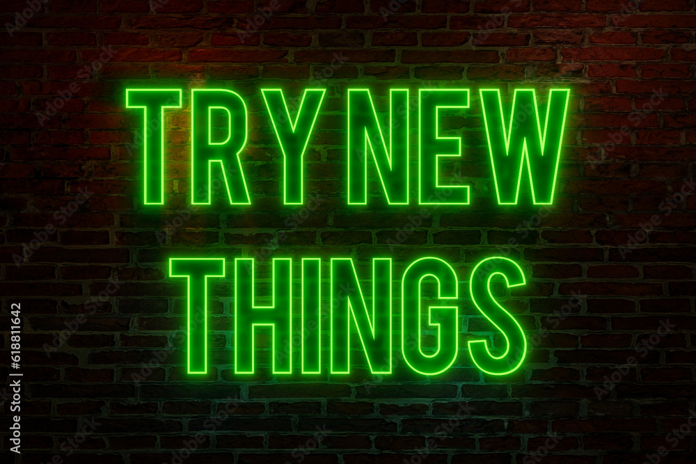 Try new things. Brick wall at night, illuminated neon text 
