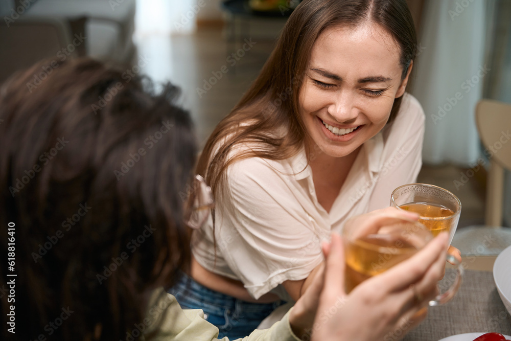 Close up photo of happy female friends holding cups Close up photo of happy female friends holding cups